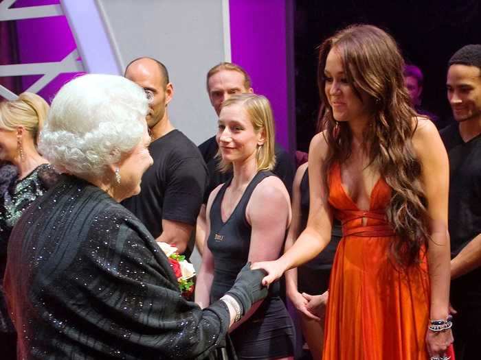 Miley Cyrus was wearing a gown with a plunging neckline while meeting Queen Elizabeth II in 2009.