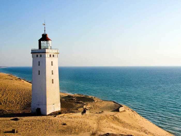 Rubjerg Knude Lighthouse in Denmark is surrounded by sand dunes.