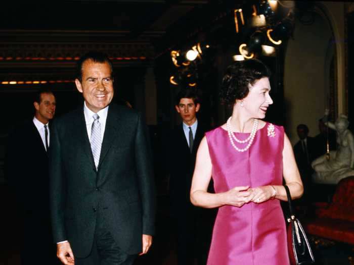 The Queen greeted President Richard Nixon while wearing a bright pink sleeveless dress in 1969.