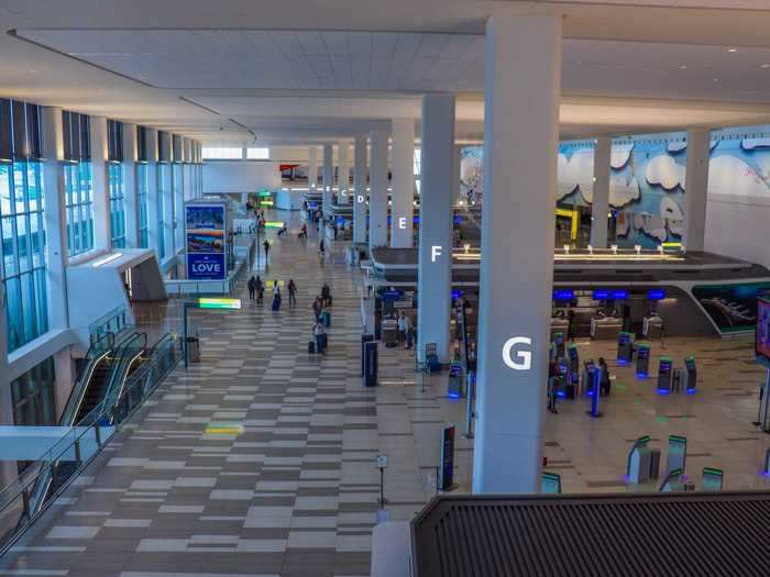 Clear windows provide a direct line of sight to the check-in areas below, as well as the art installations on display in the terminal.