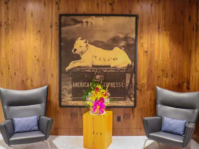 Immediately greeting all visitors is the iconic portrait of an American Express steamer and dog, accompanied by two armchairs. This setup can be found in every Centurion Lounge.