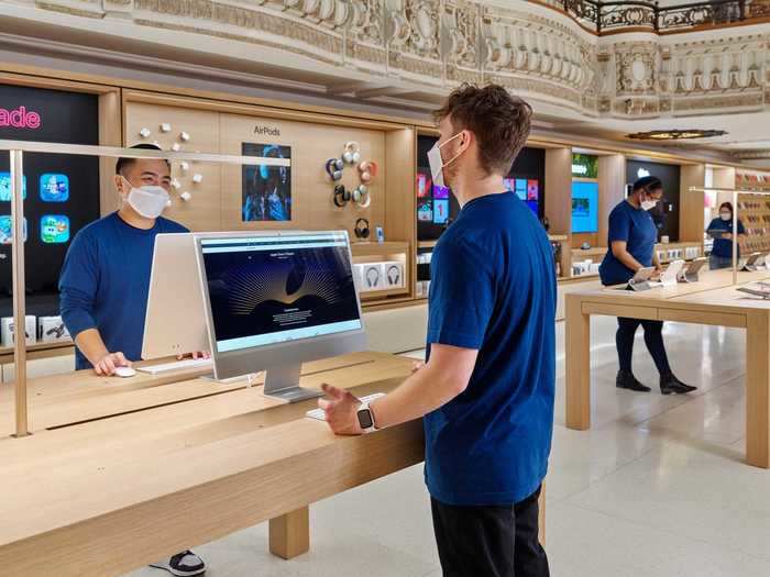 Retail workers on the sales floor at the Tower Theater Apple Store