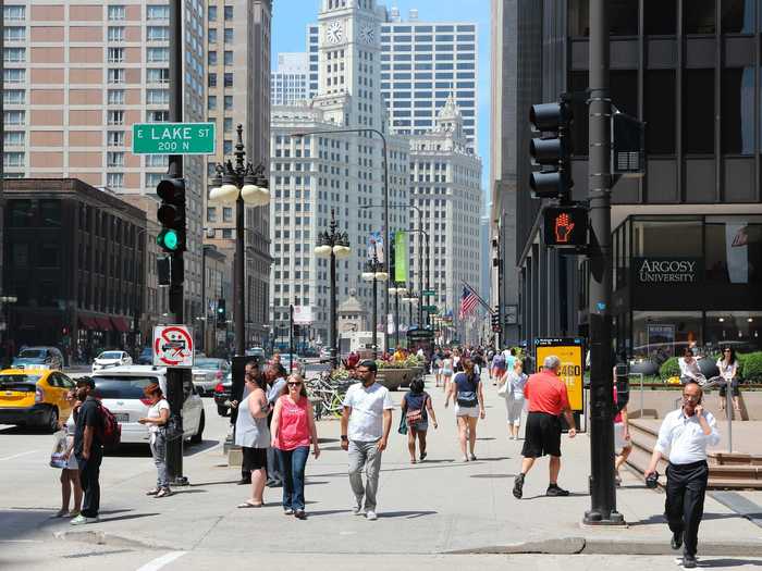 Pedestrians wave and thank cars as they cross intersections.