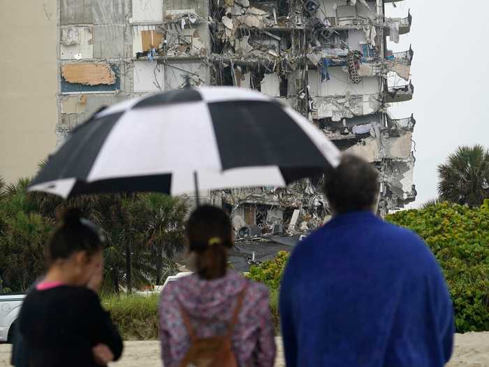 Residents look on at the damage after authorities cordon off the area.