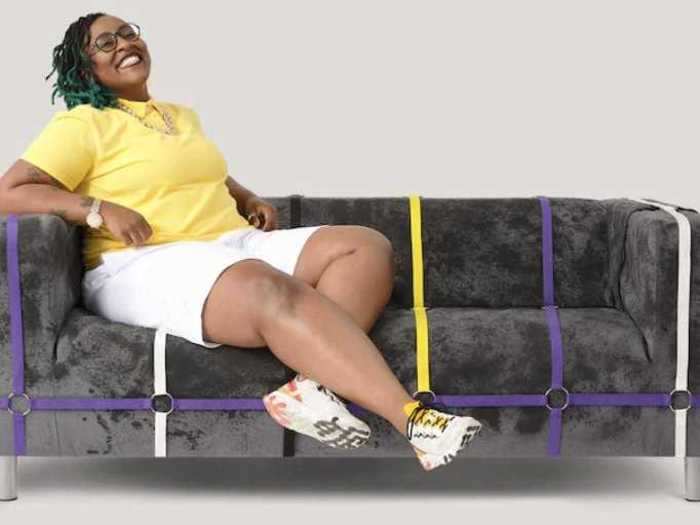 The nonbinary flag is also represented in the collection. The loveseat representing it has black, purple, yellow, and white strips running down it.