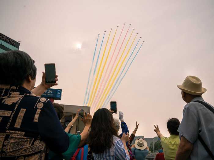 Those who gathered in the streets of Beijing were treated to the sight of jets trailing colorful smoke across the capital