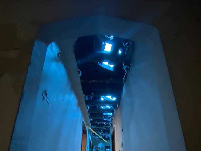 The hallway to the back bedrooms was drenched in an ominous blue light.