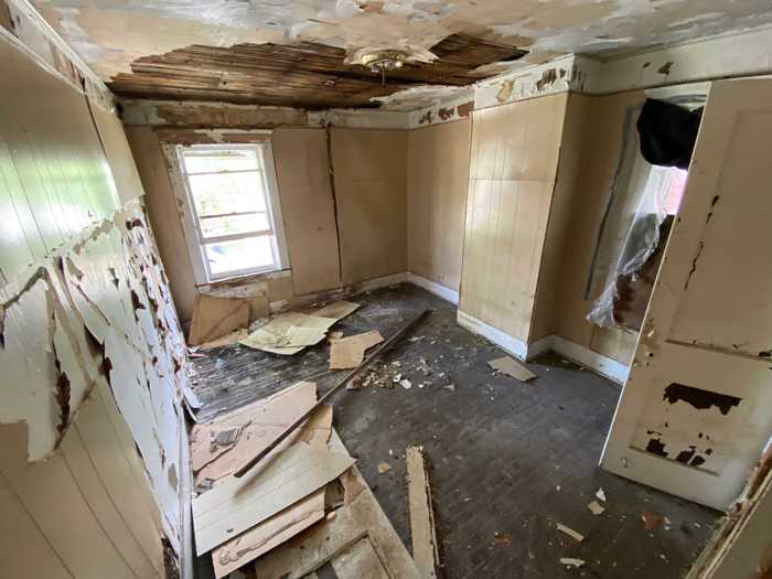 In the bedrooms, the paneling had fallen off the walls onto the charred flooring.