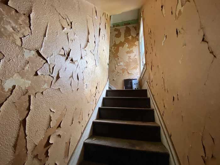 The paint along the staircase to the second floor was peeling off the walls.