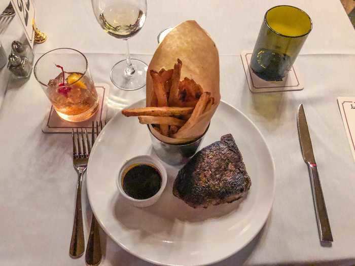 The main course is a large serving of steak and French fries.