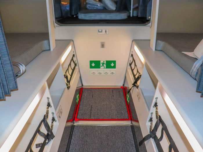 Smaller storage areas line the aisle and an emergency exit is available that will see flight attendants pop out from overhead bins in case of trouble.