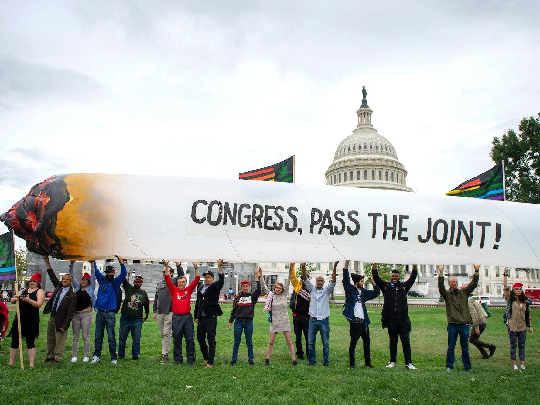 Activists holding up a giant inflatable joint during a rally at the US Capitol.