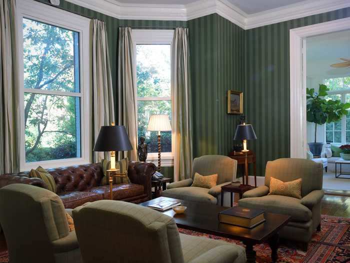 Hagan transformed the library from neutral colors to a vibrant space with green striped wallpaper and a plush leather couch.