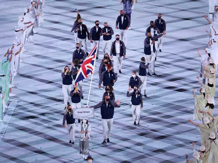 NOW: Tokyo 2020 - A small delegation of Team Great Britain athletes participate in the parade of nations while wearing masks.