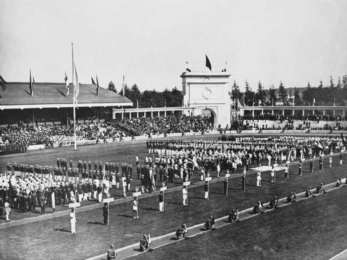 THEN: Antwerp 1920 - Teams assemble in front of a crowd for the opening ceremony of the 1920 Summer Olympics.