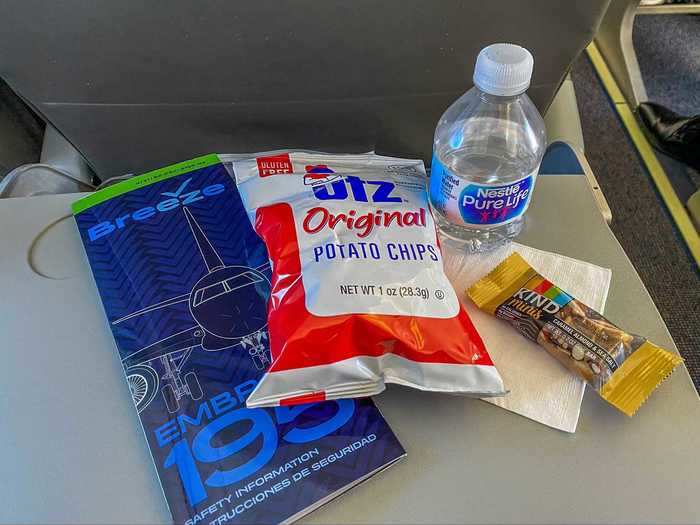 Breeze is offering snacks for the time being but the airline will move to a buy-on-board program where all snacks and drinks will require a purchase. The current offering includes Utz chips and a Kind bar.