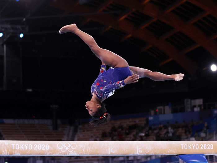 Simone Biles casually gazes at the four-inch wide balance beam.