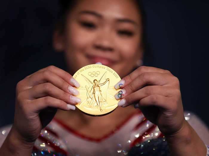 7/29: American Suni Lee holds out her Olympic gold medal from the individual all-around final.