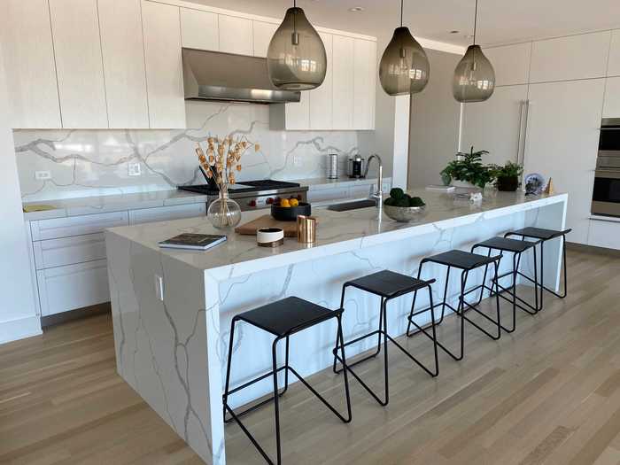 The kitchen has marble countertops and a stainless-steel oven.