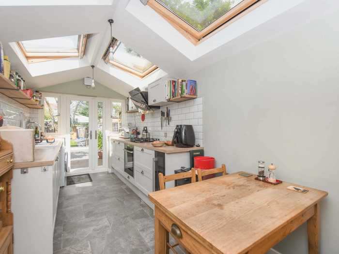 At the back end of the kitchen, glass-windowed doors lead to a garden.