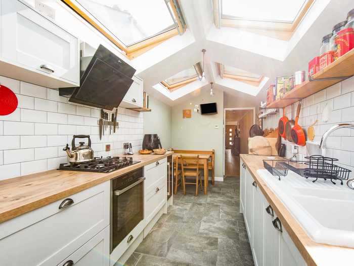 The kitchen and dining area is long and narrow with vast windows on the ceiling to bring in natural light.