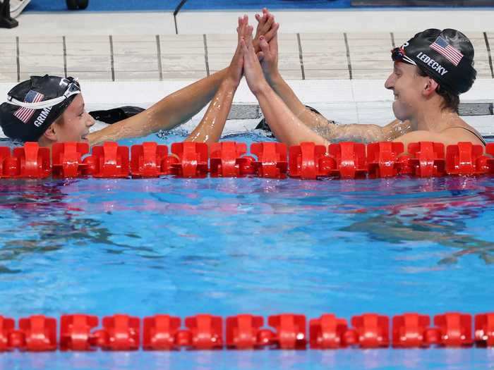 Ledecky (right) high-fives 15-year-old teammate Katie Grimes after the 800m freestyle final in Tokyo.