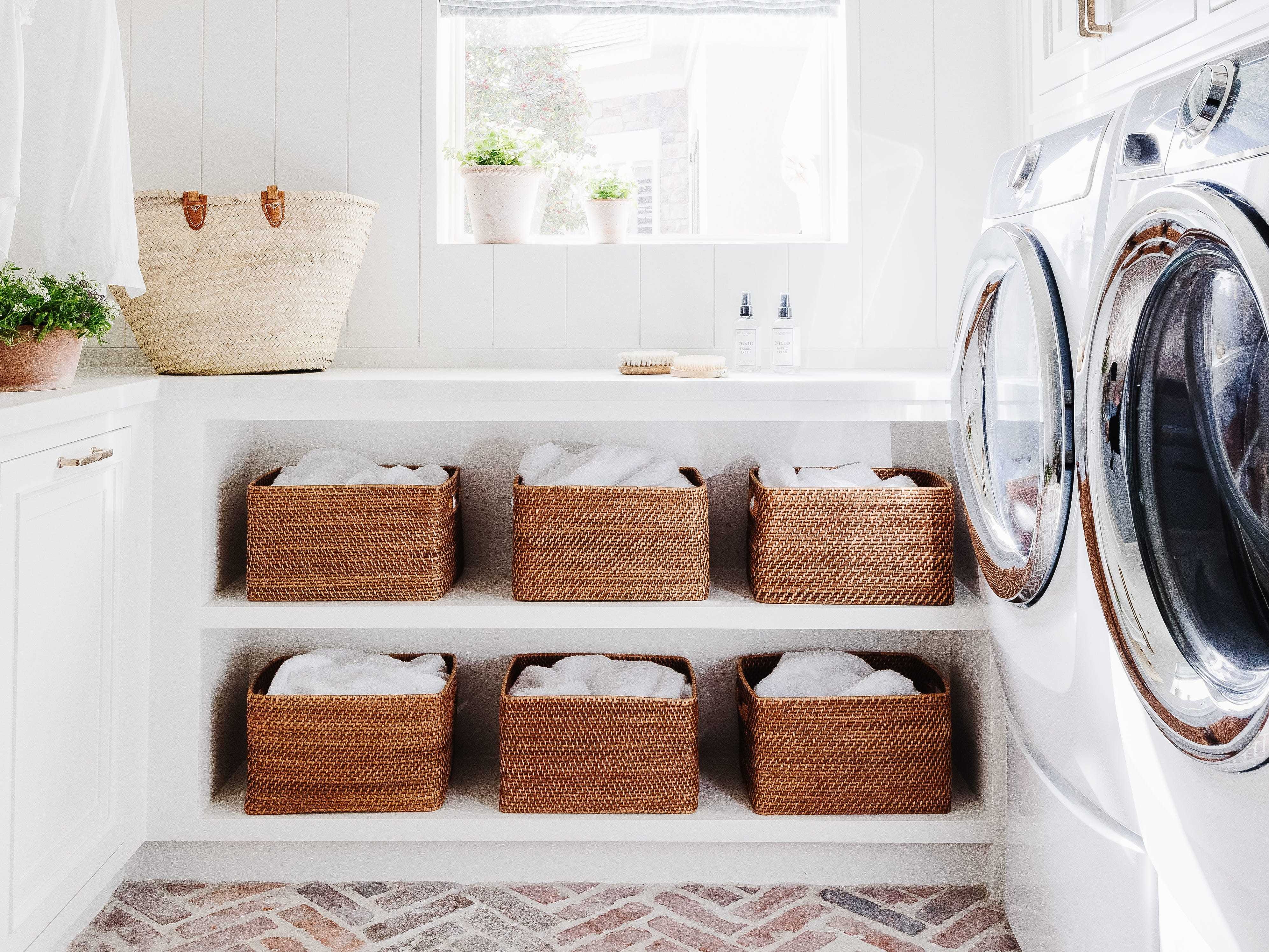 A white laundry room with shelving and baskets.