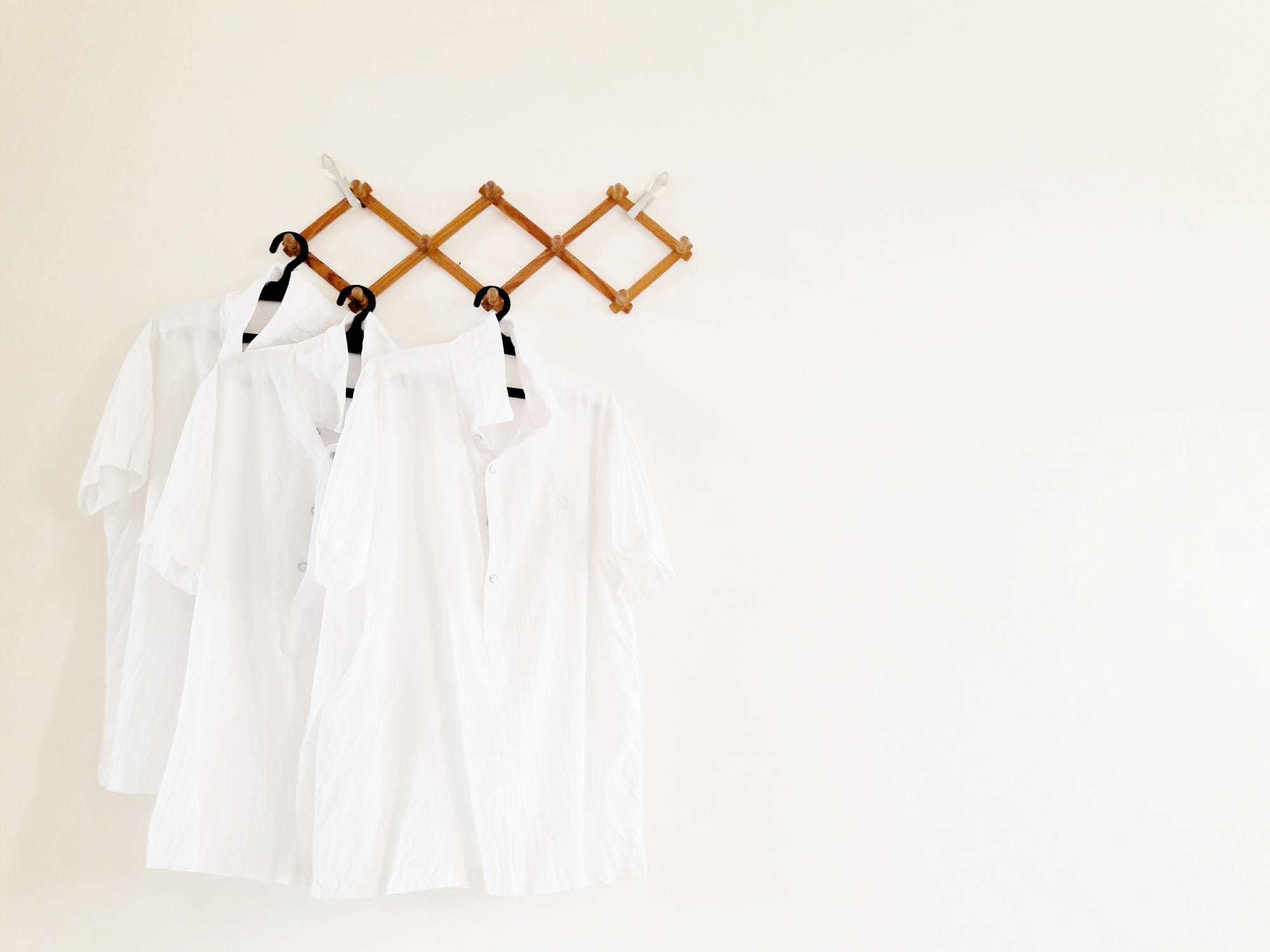 White shirts hanging on a hanging rack.