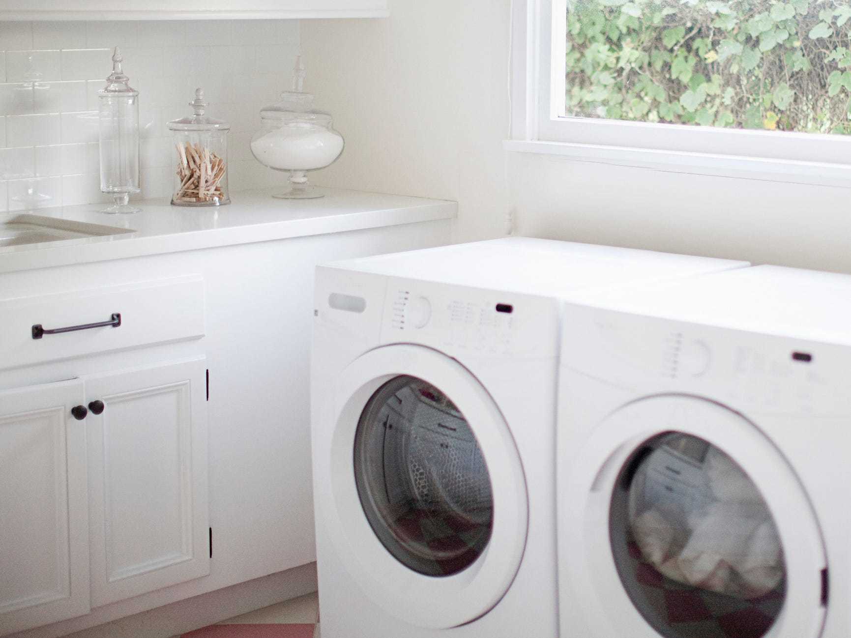 Laundry room with white appliances and cabinets.