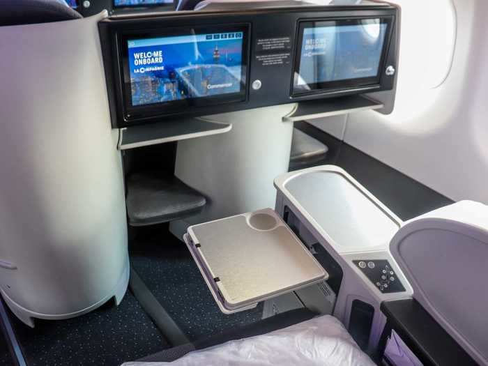 Tray tables extend from the side of the seat and can be half-extended to hold drinks or light items.