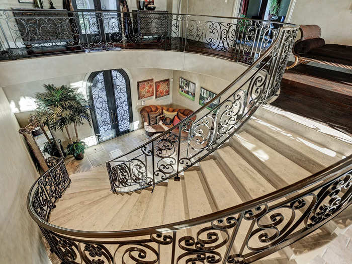 The custom iron staircase leads right to the front door. This mansion is also equipped with an elevator.