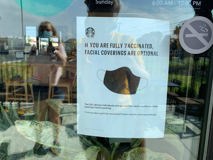 A sign on the door advised that face coverings are optional for vaccinated customers. All Starbucks employees are required to wear masks, whether or not they