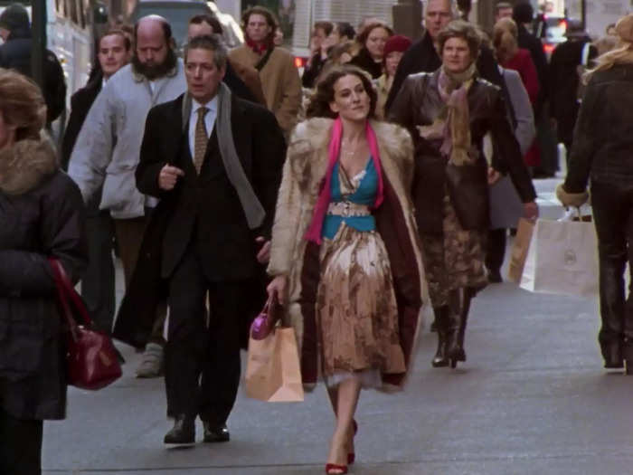 In the series finale, Carrie Bradshaw looks much more glamorous in a metallic skirt, blue belted blouse, and her iconic fur coat.