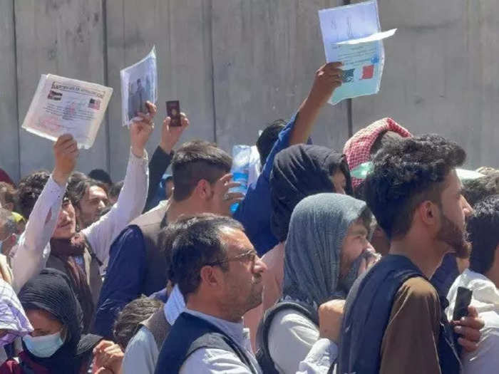 Refugees waved their documents in the air in hopes of being chosen for flights out of Afghanistan.