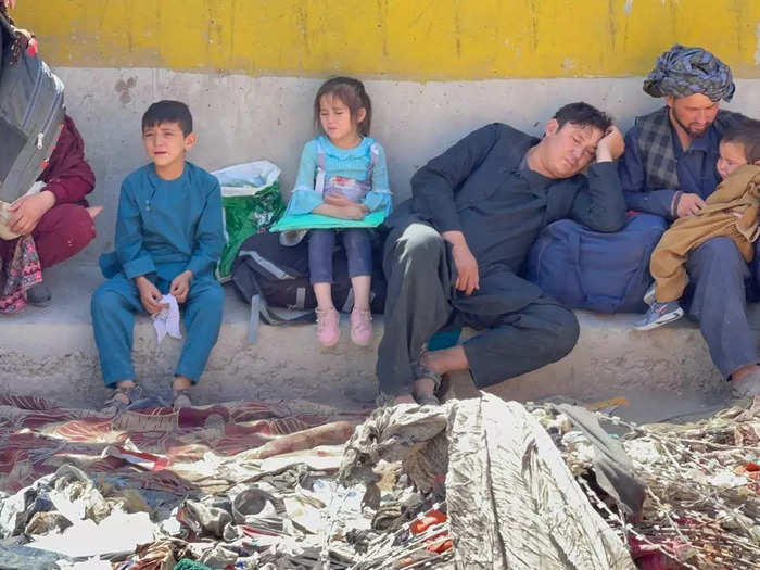 Many refugees waited outside the airport near a sewage-filled canal.