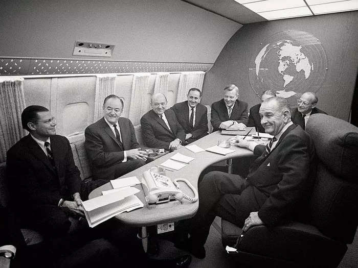 Johnson met with Cabinet members on the presidential aircraft in 1966 in a small seating area.