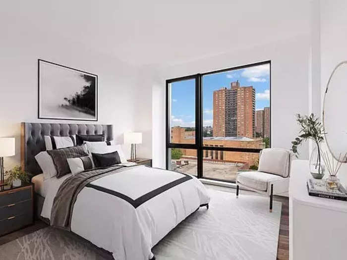 The bedroom has large windows that overlook the neighborhood.