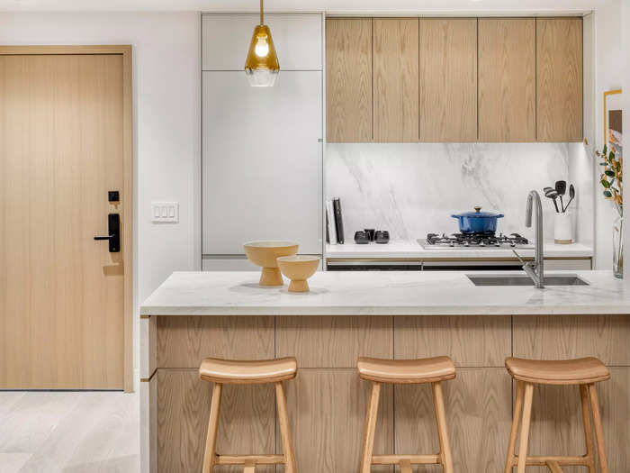 The kitchen has a large island and white countertops.