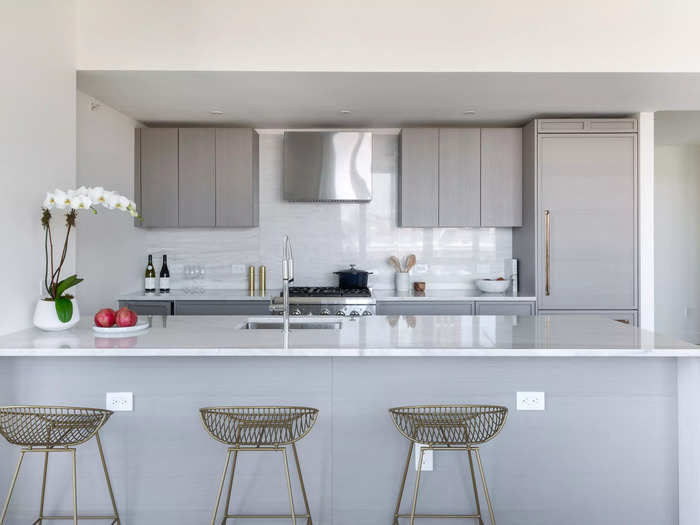 The kitchen has a large island that looks out onto the rest of the living space.