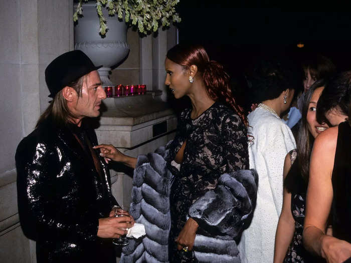 Three years later, a photographer captured designer John Galliano and model Iman as they chatted in a crowded, candlelit hallway.