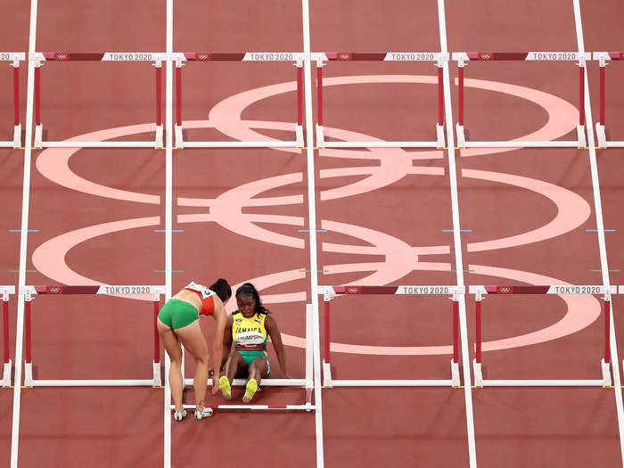 8/1: Luca Kozak of Team Hungary helps Yanique Thompson of Team Jamaica after they fell during the 100m Hurdles semifinal at the Tokyo Olympics.