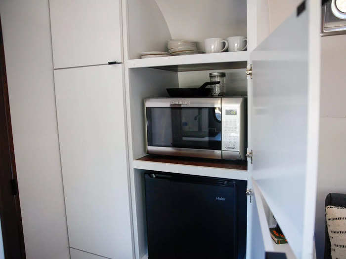 …  while a large cabinet - filled with the microwave, mini refrigerator, dishware, and glassware - is just across the way.