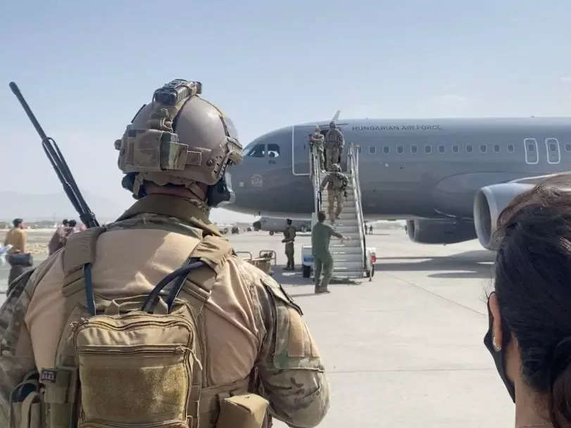 A photo the back of a soldier and a plane on the tarmac at the Kabul airport.