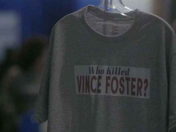 When Paula Jones (Annaleigh Ashford) heads to CPAC, she walks past t-shirts with the text "Who killed Vince Foster?," possibly a play on the WSJ op-ed headline "Who is Vince Foster?"