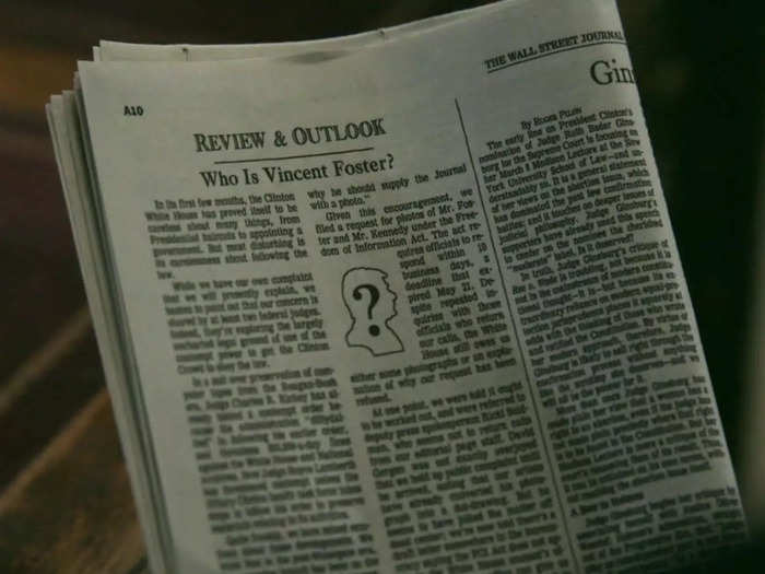 Vince Foster (Matthew Floyd Miller) is seen looking at a negative June 1993 Wall Street Journal op-ed titled "Who is Vince Foster?"