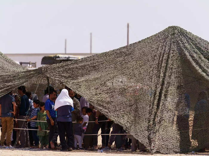 Evacuees are given a blanket, a pillow, and a hygiene kit, and sleep on Army cots.