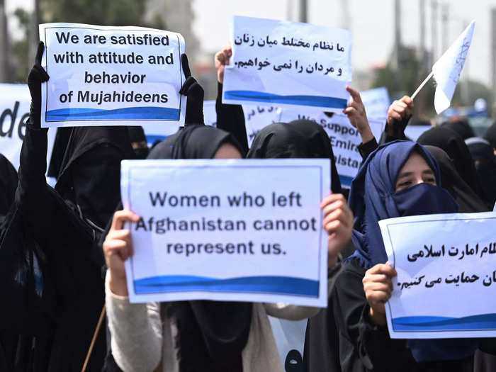 Some women held signs criticizing Afghan women who left the country.