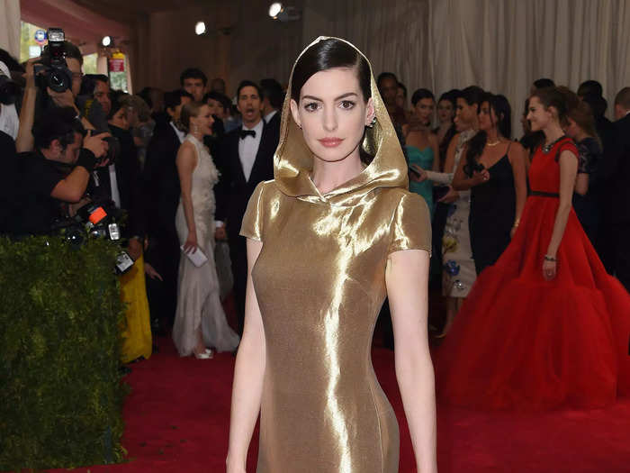 Anne Hathaway made a statement in a gold Ralph Lauren gown that had cap sleeves and a hood at the 2015 Met Gala.