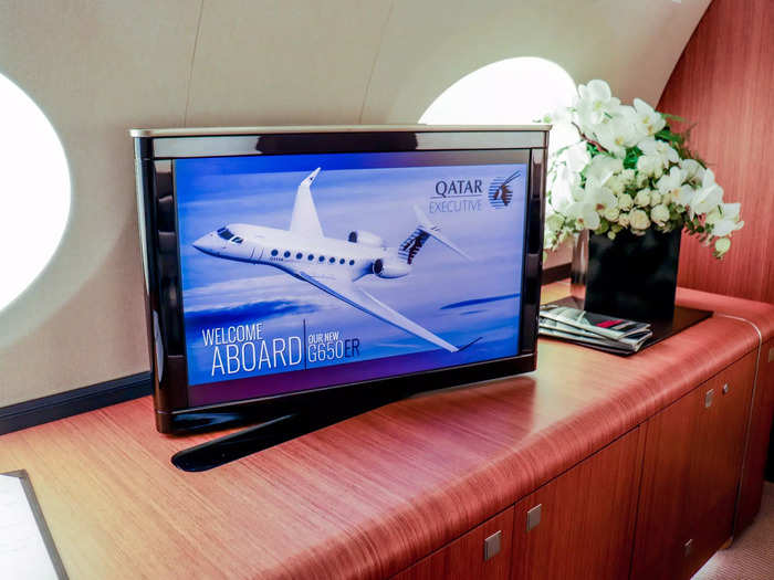 Opposite the table is a credenza with a built-in television monitor. The credenza can also be used as a buffet table during meals times, and its drawers can be used for extra storage.