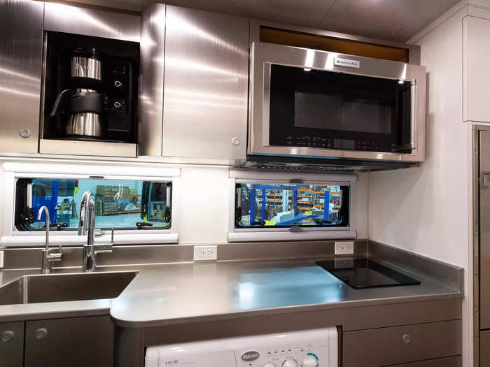 This cooking space has a single induction cooktop, cabinets, a microwave …